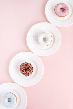 Sır pembe bir tablo üzerinde beyaz plakaları kaplı çörek