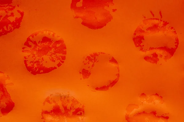 Abstraktní kulaté mokré stopy na oranžové pozadí — Stock fotografie