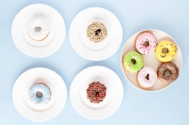 Sır mavi bir masada beyaz plakaları kaplı çörek