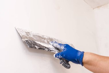 Bir spatula kullanarak duvarı hizala. İç dekorasyon.