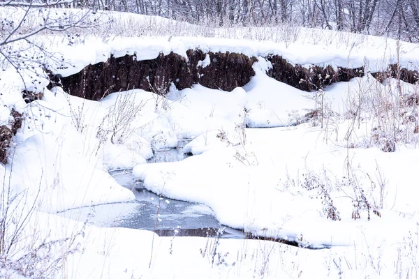 Winterliche Schneelandschaft mit nicht gefrorenem Flüsschen und Bäumen. — Stockfoto