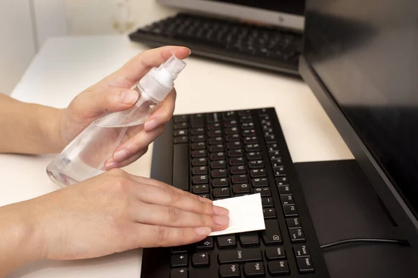 Disinfecting the computer with an antiseptic. Protection against coronavirus COVID-19 and other viruses. Wiping the keyboard.