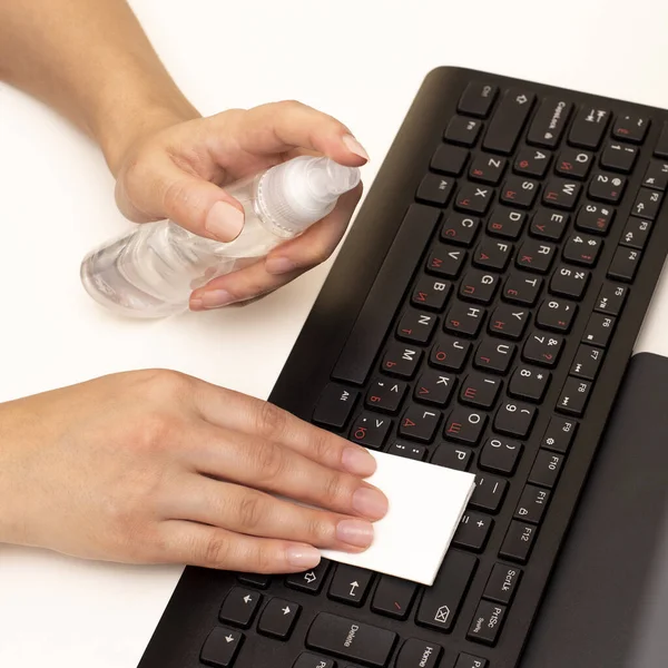 Disinfecting the computer with an antiseptic. Protection against coronavirus COVID-19 and other viruses. Wiping the keyboard.