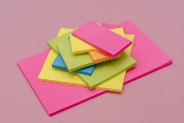 Pembe yüzeyde farklı renklerde yapış yapış. Kırtasiye.