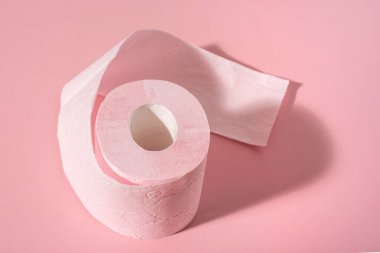 Pembe arka planda pembe bir tuvalet kağıdı rulosu. Hijyen ürünleri.