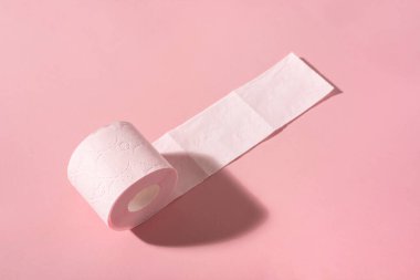 Pembe arka planda pembe bir tuvalet kağıdı rulosu. Hijyen ürünleri.