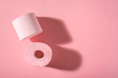 Pembe arka planda iki rulo pembe tuvalet kağıdı. Hijyen ürünleri. Üst Manzara. Boşluğu kopyala.