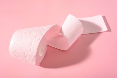 Pembe arka planda pembe bir tuvalet kağıdı rulosu. Hijyen ürünleri.
