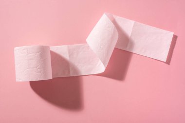 Pembe arka planda pembe bir tuvalet kağıdı rulosu. Hijyen ürünleri.