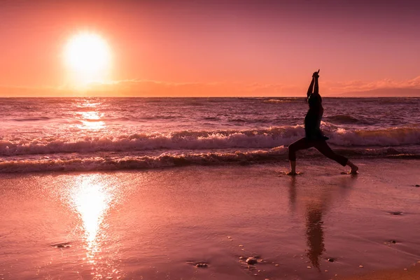 Praktykowanie jogi na plaży o zachodzie słońca — Zdjęcie stockowe