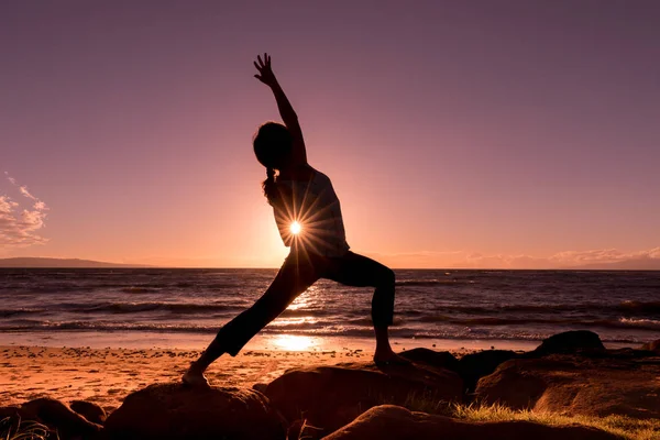 Het beoefenen van yoga op het strand bij zonsondergang — Stockfoto