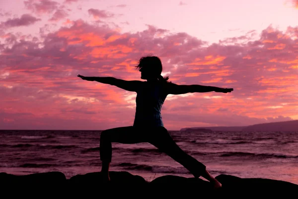 Het beoefenen van yoga op het strand bij zonsondergang — Stockfoto