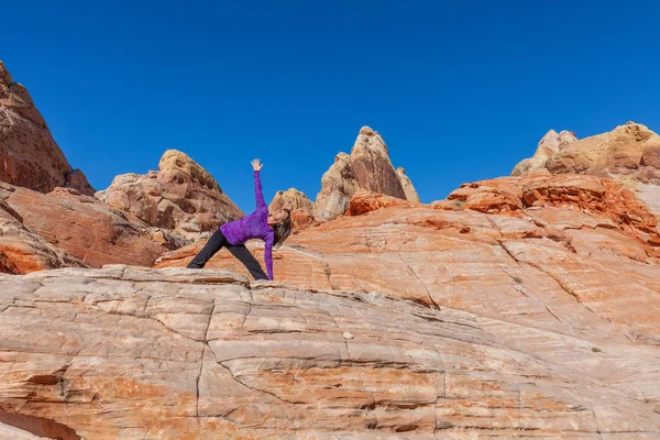 女性の美しい赤い岩砂漠で屋外ヨガの練習 — ストック写真