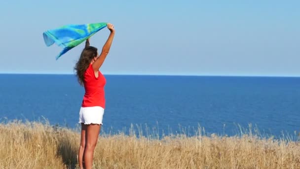 Movimento lento. Mulher sexy bonita em vermelho com capa contra o mar — Vídeo de Stock