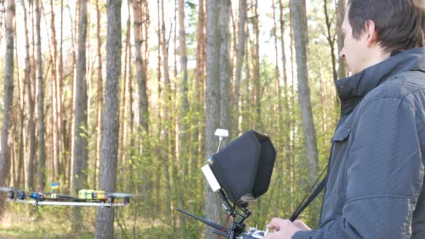 Operador de drones hombre sosteniendo transmisor en madera. 4K 3840x2160 — Vídeo de stock