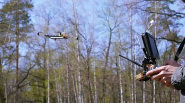 Dron operatör verici tutan adam ve drone ile faaliyet göstermektedir. 4k 3840 x 2160
