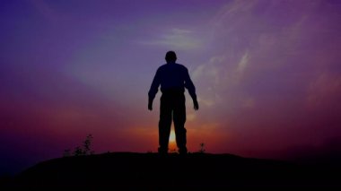  Adam (dua) üst kaldırdı elleriyle gündoğumu zaman meditasyon siluet. 4k 3840 x 2160