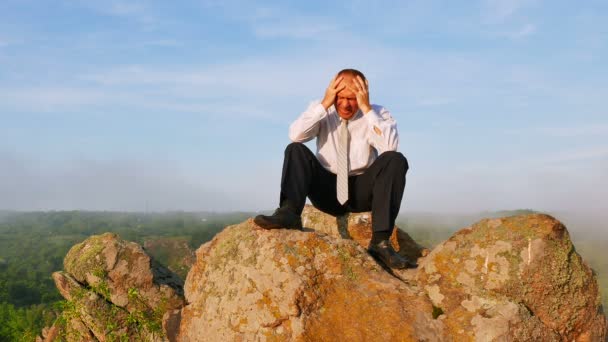 Businessman in a depression with a headache at sunrise mountain  time. 4K 3840x2160 — Stock Video