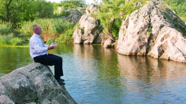 Empresário meditar perto de rio agradável no dia de verão. 4K 3840x2160 — Vídeo de Stock