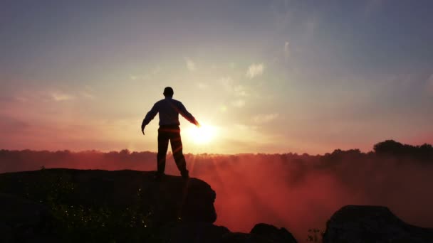 Силуэт медитирующего человека (молитва) на восходе солнца. 4K 3840x2160 — стоковое видео