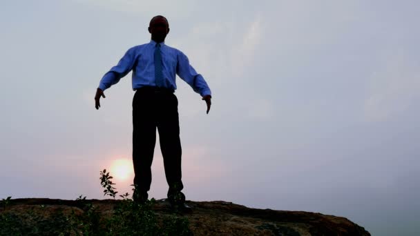 Empresário (oração) medita no topo com as mãos levantadas ao nascer do sol. 4K 3840x2160 — Vídeo de Stock