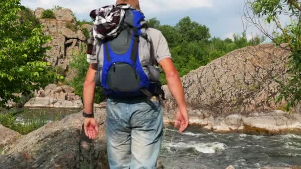 Der erwachsene Mann kommt auf dem steinernen schönen Fluss. 4k 3840x2160 — Stockvideo