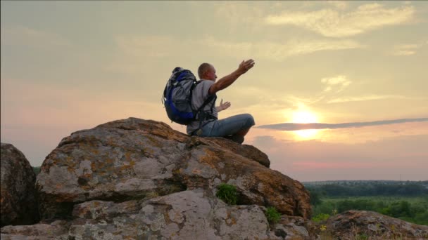 Hombre turista meditando con las manos levantadas al amanecer, al atardecer. 4K 3840x2160 — Vídeos de Stock