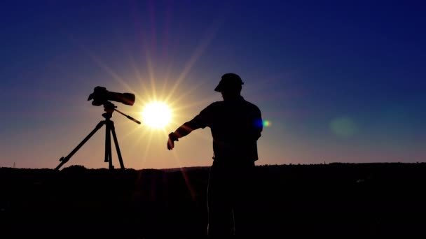 Silhueta de fotógrafo homem meditar perto da câmera com o sol. 4K 3840x2160 — Vídeo de Stock