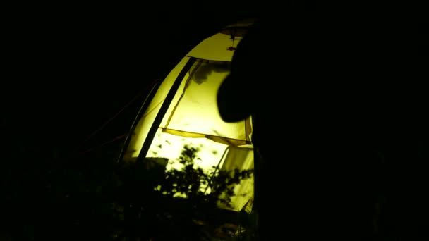 Man's tourist silhouette  with tent at night work at laptop. 4K 3840x2160 — Stock Video