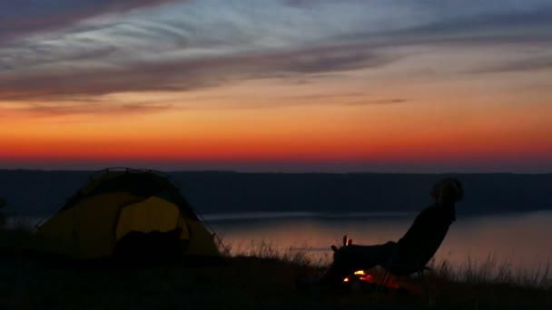 4K Tenda, falò, alba e silhouette uomo vicino al lago . — Video Stock