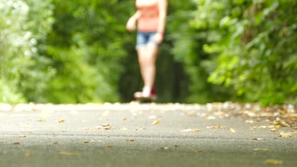 4K. Giovane bella ragazza adolescente silhouette con skateboard nel parco verde — Video Stock