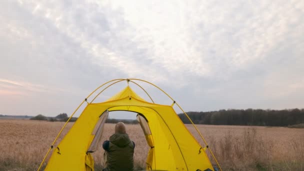 Homem Turista na tenda observando nuvens 4K. Desfasamento temporal. Produção bruta, sem aves . — Vídeo de Stock