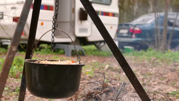 4K shot.Life al aire libre en caravana, remolque. Pilaf de cerca en fogata de madera — Vídeos de Stock