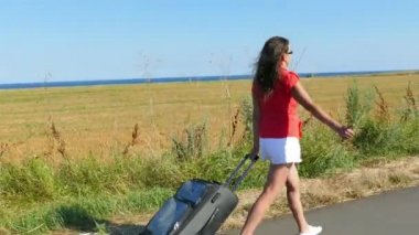  4k. Yetişkin kadın çanta ile yol ve durdurma araba gidin. Otostop takım