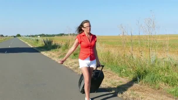 4K.Adult   Woman  with  suitcase  go on  road and stopping car. Hitchhiking team — Stock Video