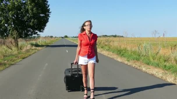 4K. Mujer sexy adulta con piernas largas con maleta en la carretera. Hora de verano — Vídeo de stock