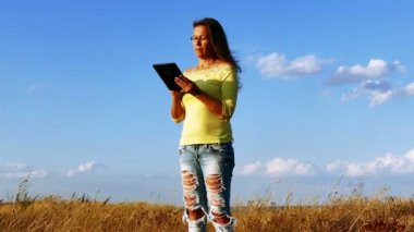 4k. Mavi gökyüzü karşı tablet ile olgun harmonous kadın