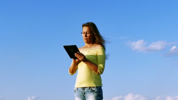 4K. Mature harmonous serios  woman with tablet and blue sky — Stock Video