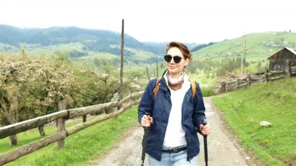 4 k. vonzó lány természetjáró turista-val a backpack megy fel, a hegyi falu — Stock videók