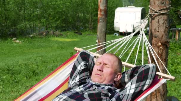 4K. Adult man traveller with trailer have rest in hammock — Stock Video