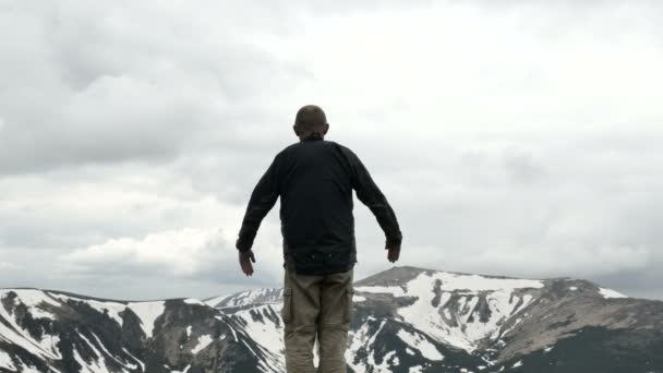 4K. Hombre viajero turístico medita en la cima de la montaña. Slider tiro — Vídeo de stock