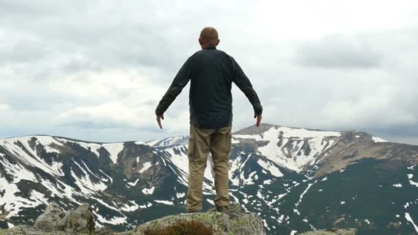 4K. Hombre viajero turístico medita en la cima de la montaña. Cambio de enfoque — Vídeos de Stock