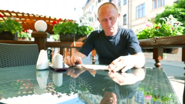 4K. Homem adulto faz escolha de pratos no café de rua — Vídeo de Stock