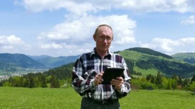 4k. Zevk yaşam. Adam tablet bilgisayar ile dağlar tepede. Odak Değiştir