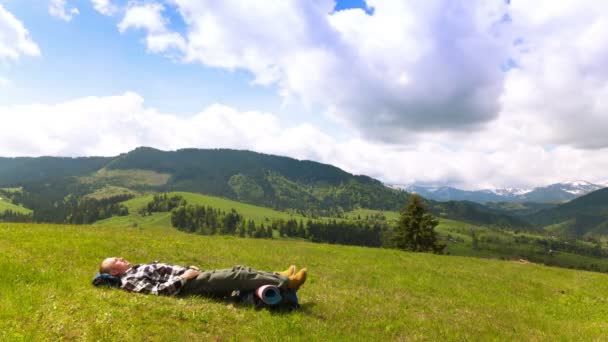 4K. Hombre mochilero turístico tienen descanso durmiendo en las montañas colina . — Vídeos de Stock