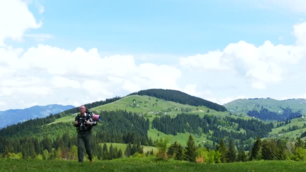 4K .M un turista sulla collina di montagna nella giornata di sole. Backpacker team turistico — Video Stock