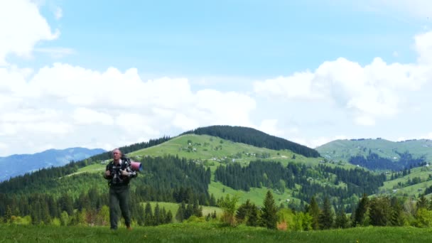 4k. M een toeristische op berg heuvel in zonnige dag. Backpacker toeristische team — Stockvideo