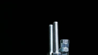 Fındık ile iki cıvata koyu arka planı döndürür. 4k yakın merkezi tarafı yukarı