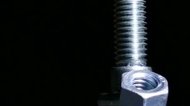 Somun ve cıvata döner koyu arka planı. 4 k makro
