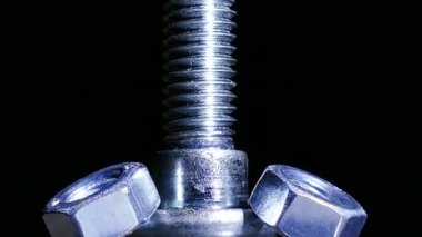 İki somun ve cıvata döner koyu arka planı. 4 k makro